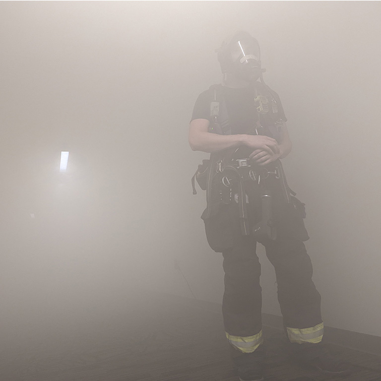 A fireman wearing a gas mask in a smoke-filled hallway at the Great Escape, Bloomington, Indiana