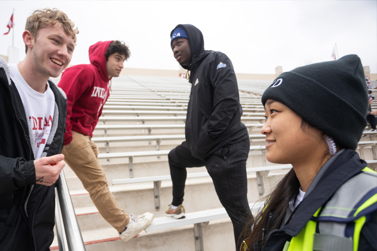 An IUPD cadette chats with a diverse group of students on the stadium risers at Memorial Stadium, on the IU Bloomington campus. 