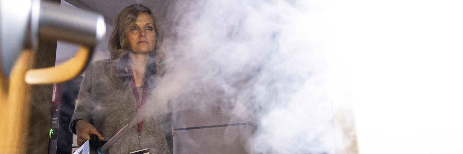 A dramatic photo of a woman using a smoke machine as part of an environmental inspection on the IU campus, early 2022.
